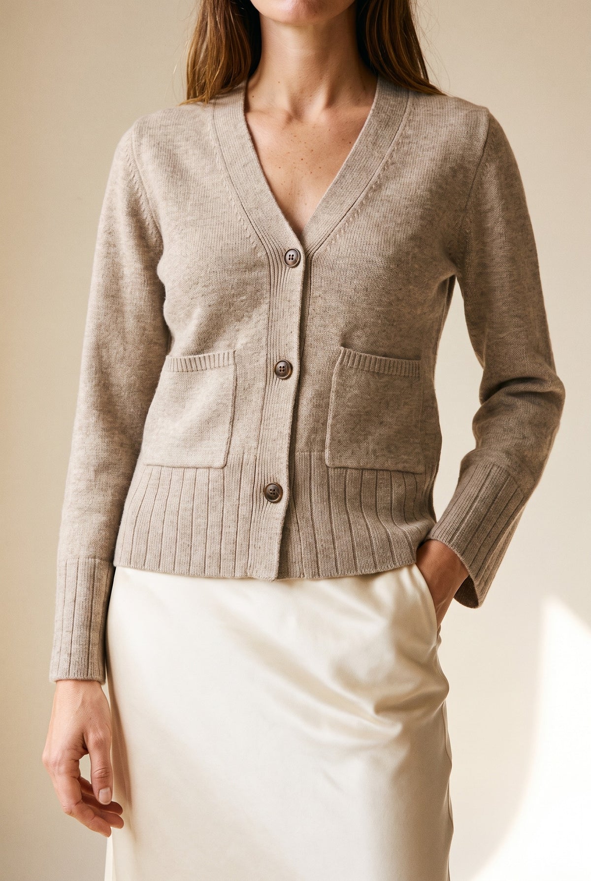The Allison Cardigan in beige — V-neck and patch pocket detail